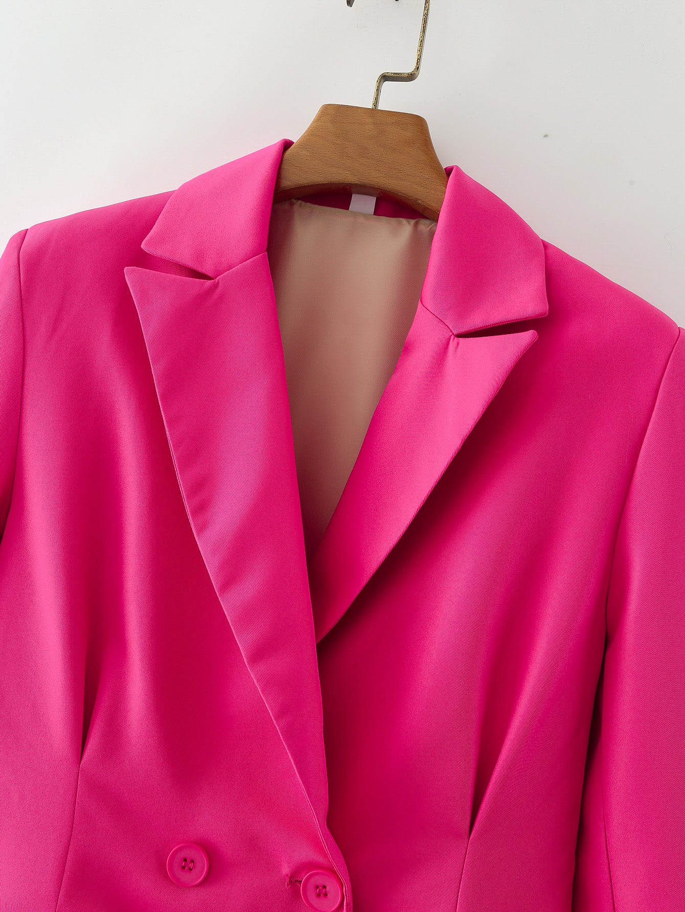 Les femmes portent un blazer slim plissé à double boutonnage rouge rose au début du printemps